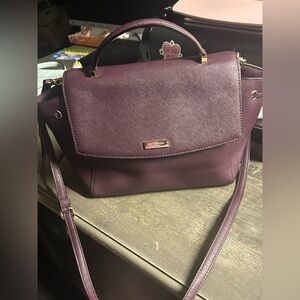 Kate Spade Laurel Way Lilah satchel in a burgundy or mulberry color.